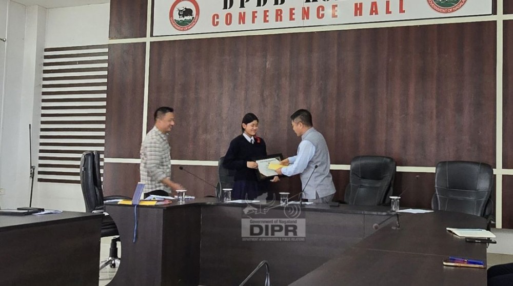 Deputy Commissioner Kohima B Henok Buchem felicitates Visezono Vakha of Rüzhükhrie GHSS, Kohima, for securing the highest aggregate among all Government High Schools in Kohima district in the HSLC Examination 2026 on May 26. (DIPR Photo)